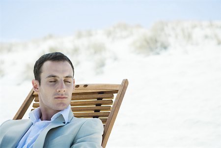 Businessman sitting in lounge chair on beach, eyes closed Stock Photo - Premium Royalty-Free, Code: 633-01574633
