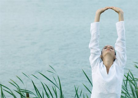 reeds - Woman stretching arms over head, lake in background Foto de stock - Sin royalties Premium, Código: 633-01572604