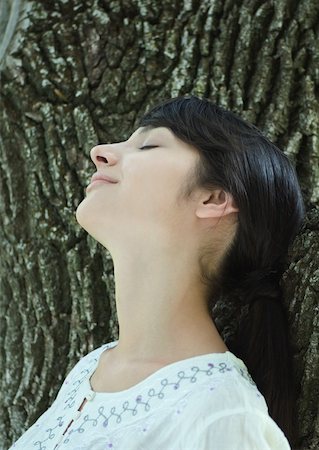 simsearch:633-01572737,k - Woman with head against tree trunk, eyes closed, smiling Foto de stock - Royalty Free Premium, Número: 633-01572645