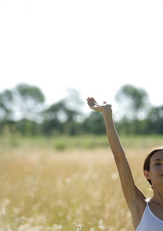 simsearch:633-01572611,k - Woman standing in field with arm up, cropped view Stock Photo - Premium Royalty-Free, Code: 633-01572783