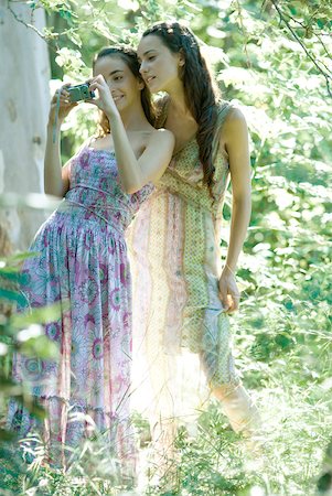 simsearch:632-05553991,k - Two young women wearing sun dresses, standing in forest, looking at digital camera Stock Photo - Premium Royalty-Free, Code: 633-01573215