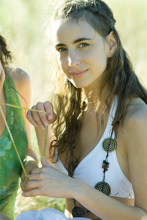 portrait hippies - Woman holding part of friend's necklace Stock Photo - Premium Royalty-Free, Code: 633-01573242