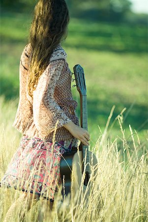 simsearch:633-01715215,k - Femme jeune hippie debout dans un champ, guitare holding, vue arrière Photographie de stock - Premium Libres de Droits, Code: 633-01573267