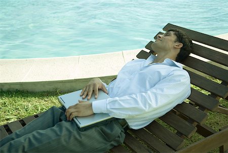 swimming pool man laptop - Businessman reclining in lounge chair near pool, holding laZSop on lap Stock Photo - Premium Royalty-Free, Code: 633-01573587