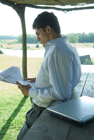 simsearch:633-01573622,k - Businessman standing under outdoor shelter, looking at blueprints Foto de stock - Royalty Free Premium, Número: 633-01573591