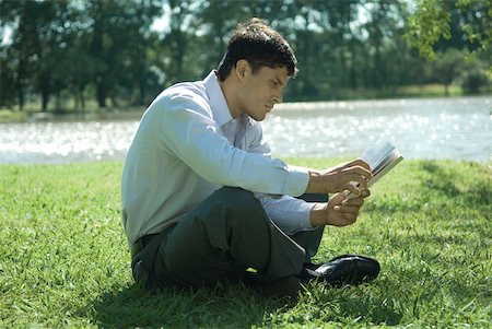 simsearch:633-01573622,k - Businessman sitting on grass, reading Foto de stock - Royalty Free Premium, Número: 633-01573612