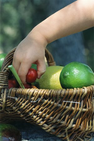simsearch:633-01272776,k - Child reaching for fruit in basket full of fresh produce Foto de stock - Royalty Free Premium, Número: 633-01573659
