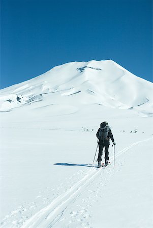 simsearch:832-03723590,k - Skier heading toward mountain, rear view Fotografie stock - Premium Royalty-Free, Codice: 633-01573710