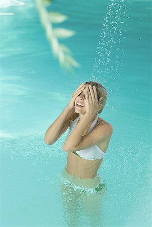 standing person covering eyes - Young woman in pool, standing under stream of water, covering eyes Stock Photo - Premium Royalty-Free, Code: 633-01573874