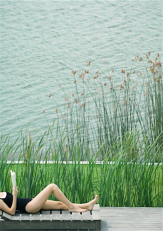 Young woman lying on lounge chair, reading Foto de stock - Sin royalties Premium, Código: 633-01573960