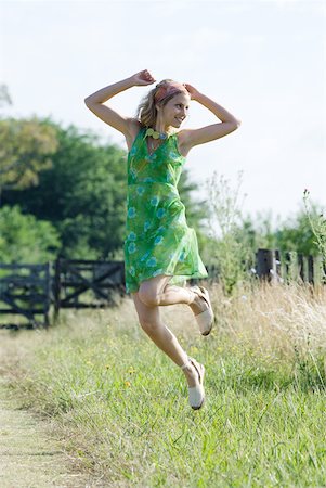 simsearch:633-01714195,k - Young woman in sundress jumping in rural field Stock Photo - Premium Royalty-Free, Code: 633-01714086