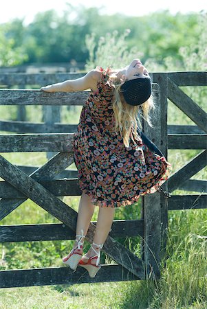 simsearch:633-01714195,k - Young woman holding on to wooden fence, head back, rear view Stock Photo - Premium Royalty-Free, Code: 633-01714145