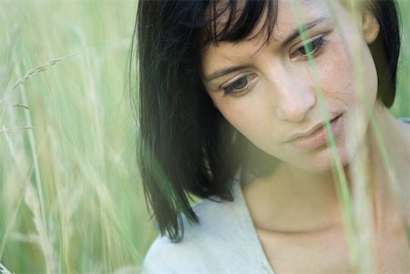 simsearch:633-01992734,k - Young woman in tall grass, looking down, portrait Foto de stock - Royalty Free Premium, Número: 633-01714236