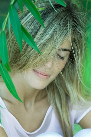 simsearch:633-01572611,k - Young woman among foliage, hair covering face, eyes closed Stock Photo - Premium Royalty-Free, Code: 633-01714260