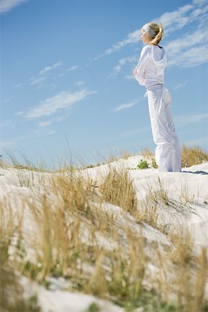 Young woman standing on dune with eyes closed and arms crossed, side view, full length Stock Photo - Premium Royalty-Free, Code: 633-01714368