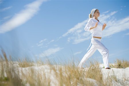 simsearch:633-01714395,k - Young woman standing on dune, exercising Foto de stock - Sin royalties Premium, Código: 633-01714370