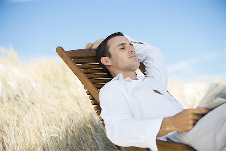 Young man sitting in deck chair, napping Stock Photo - Premium Royalty-Free, Code: 633-01714429