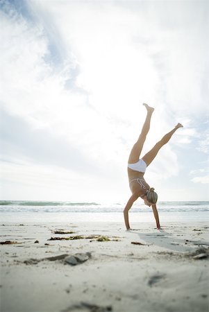 simsearch:633-01274929,k - Young woman in bikini standing on hands on beach, full length Stock Photo - Premium Royalty-Free, Code: 633-01714467