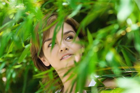 simsearch:633-01714236,k - Young woman standing among foliage, looking up Foto de stock - Sin royalties Premium, Código: 633-01714587