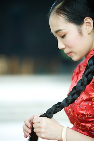 simsearch:633-01714691,k - Young woman wearing traditional Chinese clothing, holding long braid Foto de stock - Royalty Free Premium, Número: 633-01714641