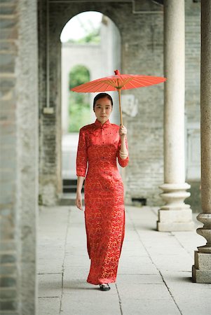 simsearch:633-01714691,k - Young woman wearing traditional Chinese clothing, walking with parasol Foto de stock - Royalty Free Premium, Número: 633-01714659