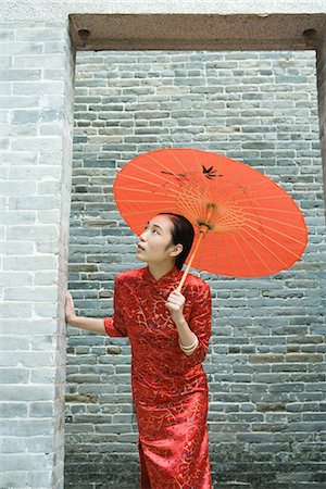 simsearch:633-01714698,k - Young woman wearing traditional Chinese clothing, holding parasol, looking up through doorway Stock Photo - Premium Royalty-Free, Code: 633-01714652