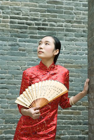 simsearch:633-01714691,k - Young woman wearing traditional Chinese clothing, holding fan Foto de stock - Royalty Free Premium, Número: 633-01714653