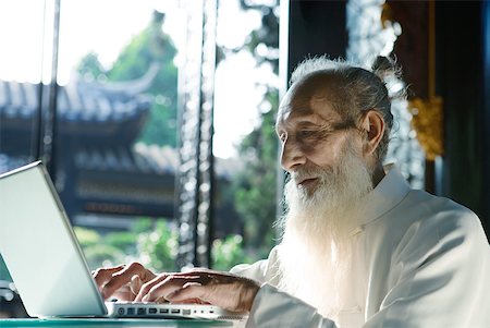 simsearch:633-01715938,k - Elderly man wearing traditional Chinese clothing, using laZSop Stock Photo - Premium Royalty-Free, Code: 633-01714709