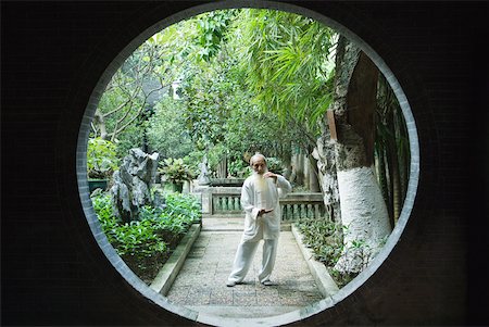 simsearch:695-03378158,k - Elderly man wearing traditional Chinese clothing doing Tai Chi Fotografie stock - Premium Royalty-Free, Codice: 633-01714721