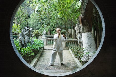 Elderly man wearing traditional Chinese clothing doing Tai Chi Stock Photo - Premium Royalty-Free, Code: 633-01714722