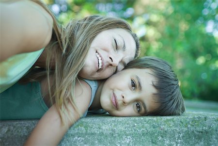 simsearch:695-03375963,k - Boy and mother lying down, woman resting head on boy, boy smiling at camera Stock Photo - Premium Royalty-Free, Code: 633-01714811