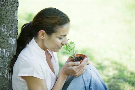 simsearch:633-01572611,k - Woman sitting outdoors, smelling pot of herbs Stock Photo - Premium Royalty-Free, Code: 633-01714880