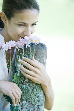 simsearch:696-03402447,k - Woman leaning on wooden post, smelling flowers Foto de stock - Sin royalties Premium, Código: 633-01714890