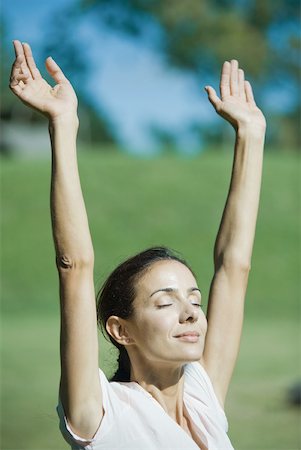 simsearch:633-01572611,k - Woman outdoors in sun with arms raised, smiling, eyes closed Stock Photo - Premium Royalty-Free, Code: 633-01714891