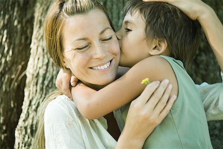 simsearch:632-02416107,k - Mother and son, woman holding flower, boy kissing her cheek Stock Photo - Premium Royalty-Free, Code: 633-01714972