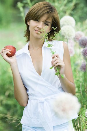 simsearch:633-01715082,k - Young woman holding sprig of herbs and apple, looking at camera Stock Photo - Premium Royalty-Free, Code: 633-01715050