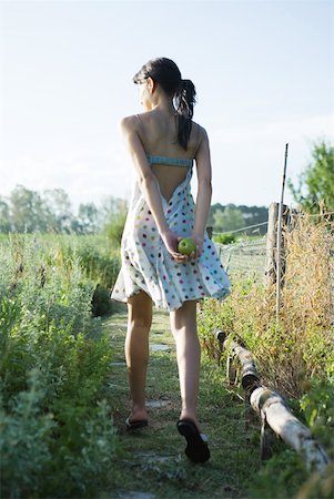 Young woman walking through garden with apple behind back, rear view Foto de stock - Sin royalties Premium, Código: 633-01715071