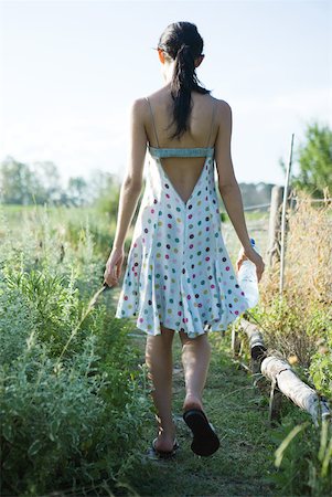 simsearch:633-01715082,k - Young woman walking through garden with bottle of water, rear view Stock Photo - Premium Royalty-Free, Code: 633-01715072