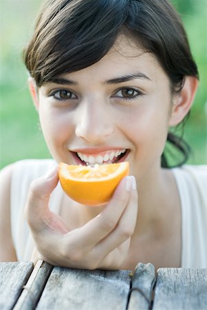 simsearch:633-01715082,k - Young woman eating slice of orange Stock Photo - Premium Royalty-Free, Code: 633-01715093