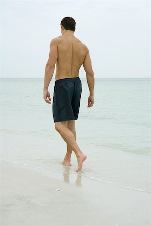Man walking in surf, rear view Stock Photo - Premium Royalty-Free, Code: 633-01715187