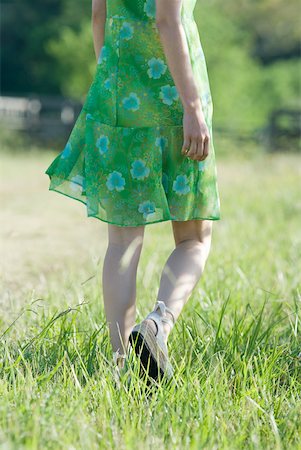 Young woman in sundress walking through field Stock Photo - Premium Royalty-Free, Code: 633-01715226