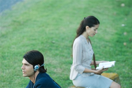 reading on park bench - People sitting in park, man listening to headphones while woman reads book Stock Photo - Premium Royalty-Free, Code: 633-01715278