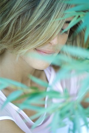 simsearch:633-01572611,k - Woman smiling, eyes closed, blurred vegetation in foreground Stock Photo - Premium Royalty-Free, Code: 633-01715438