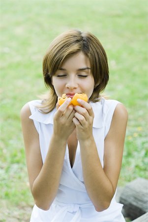 simsearch:693-06021794,k - Young woman smelling piece of fruit, eyes closed Stock Photo - Premium Royalty-Free, Code: 633-01715527