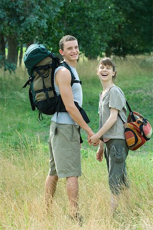Young couple going for hike, looking over shoulders, laughing Foto de stock - Sin royalties Premium, Código: 633-01715620