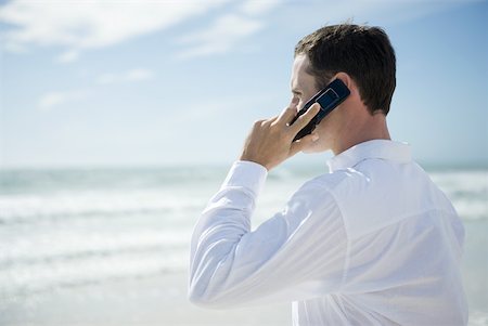 person standing mobile beach - Young man using cell phone on beach, side view Stock Photo - Premium Royalty-Free, Code: 633-01715660