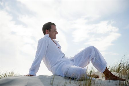 Young man lounging on dune, side view Stock Photo - Premium Royalty-Free, Code: 633-01715689