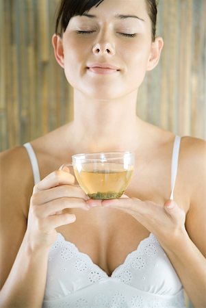 Young woman holding cup of herbal tea, eyes closed Stock Photo - Premium Royalty-Free, Code: 633-01715735