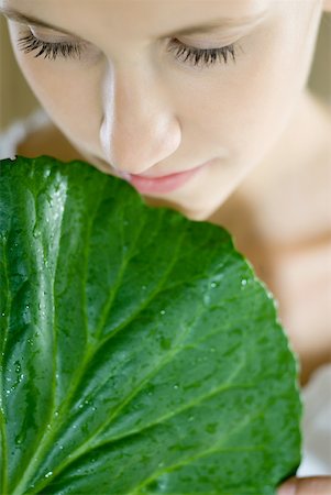 skincare leaf - Young woman holding leaf up to face, close-up, cropped Stock Photo - Premium Royalty-Free, Code: 633-01715750