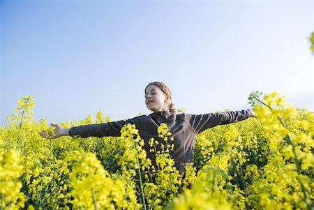 renewable - Girl standing in field of canola in bloom, arms out and eyes closed Stock Photo - Premium Royalty-Free, Code: 633-01715826